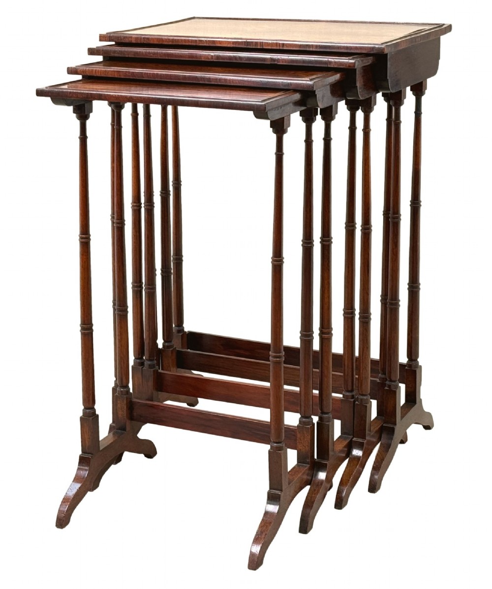 A set of four Regency period rosewood quartetto nesting tables with slender faux-bamboo turned legs and trestle feet.