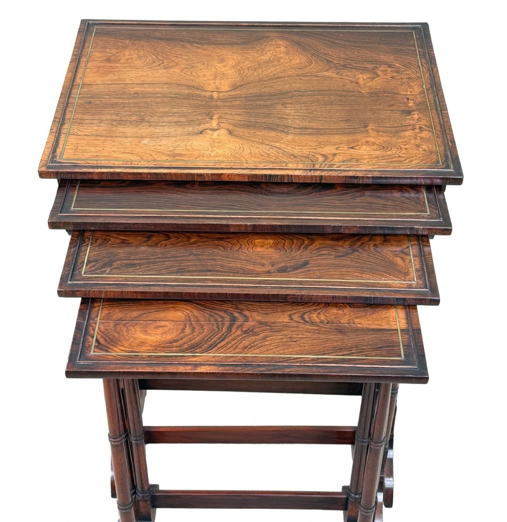 A set of four Regency period rosewood quartetto nesting tables with slender faux-bamboo turned legs and trestle feet. View II