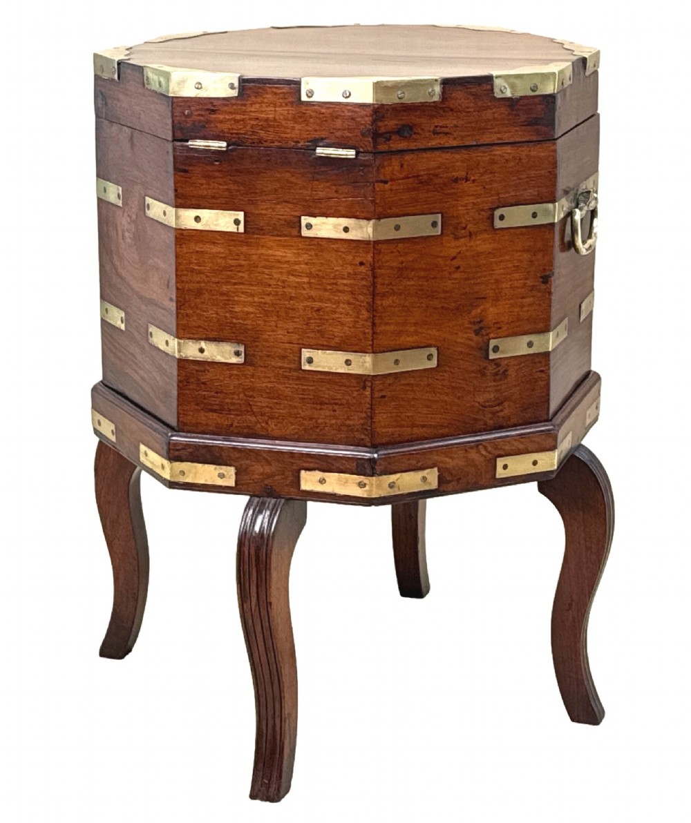 An octagonal eighteenth-century Anglo-Indian padouk wood cellarette with brass corner straps, keyhole escutcheon, and carrying handles, supported on four cabriole legs. View V
