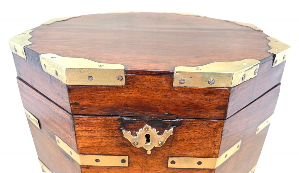 An octagonal eighteenth-century Anglo-Indian padouk wood cellarette with brass corner straps, keyhole escutcheon, and carrying handles, supported on four cabriole legs. View X