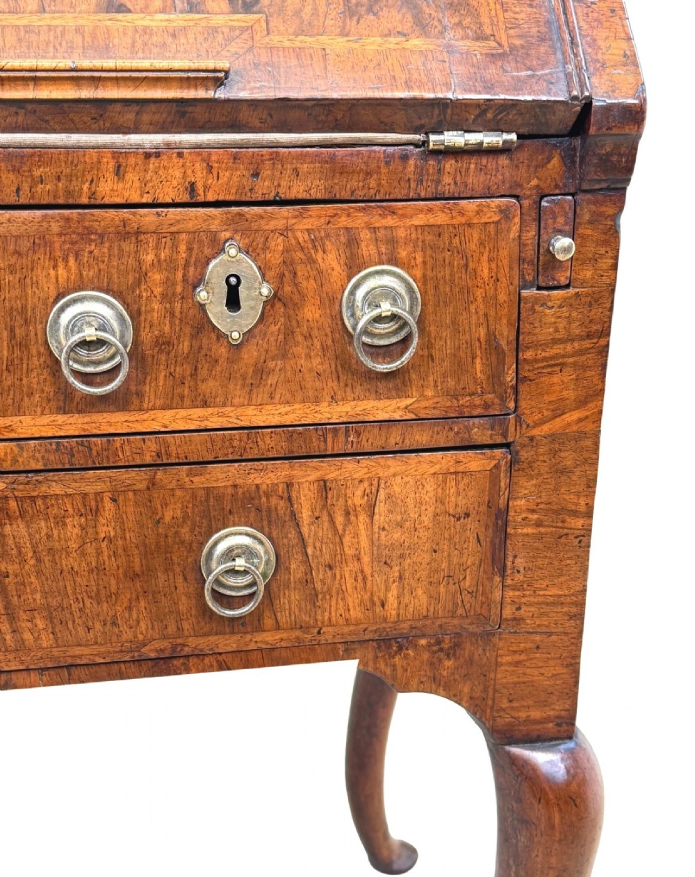 An early 18th-century walnut bureau on legs featuring a slant-front lid, small drawers with brass teardrop handles, and cabriole legs. View XII