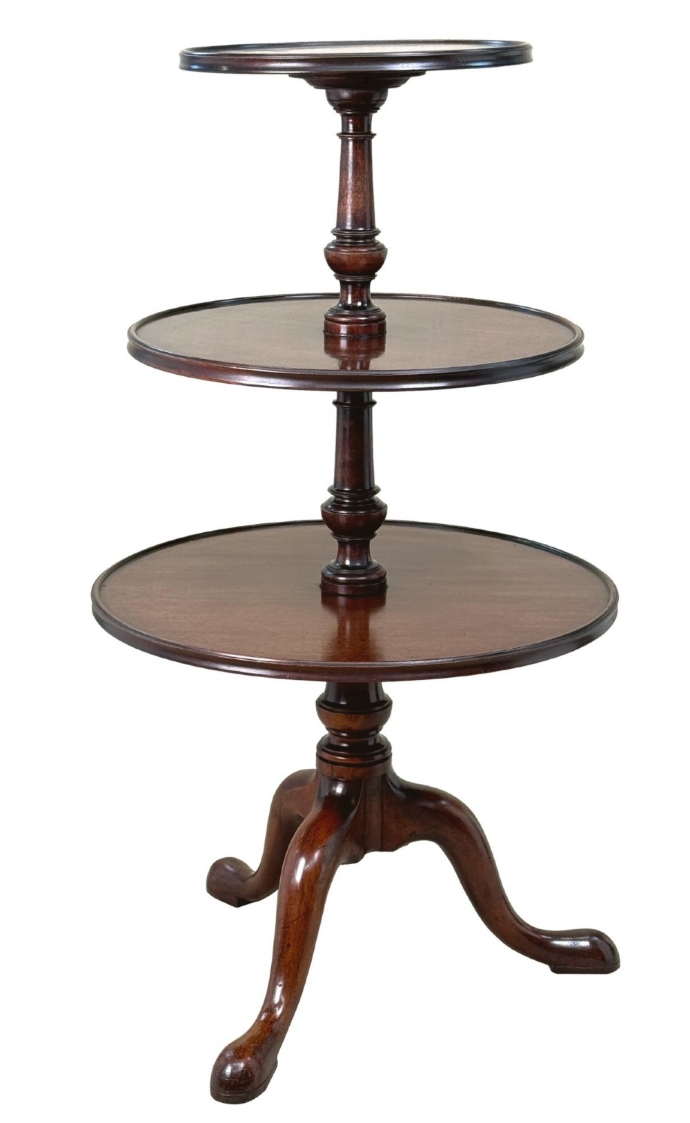 An 18th-century Georgian mahogany dumbwaiter featuring three graduated circular dished tiers supported by a turned central column and a tripod base with pad feet.
