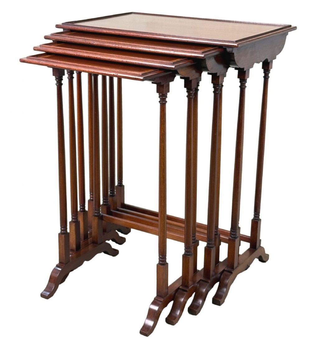 A 19th-century set of four graduated mahogany nesting tables featuring slender turned spindle legs and sledge feet.