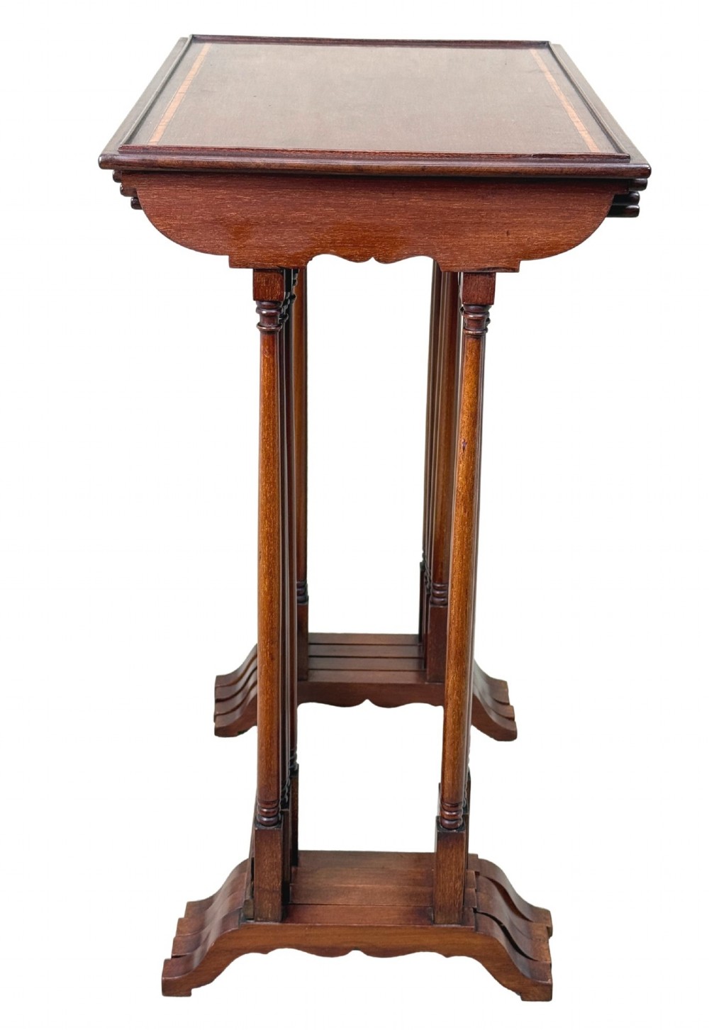 A 19th-century set of four graduated mahogany nesting tables featuring slender turned spindle legs and sledge feet. View VII