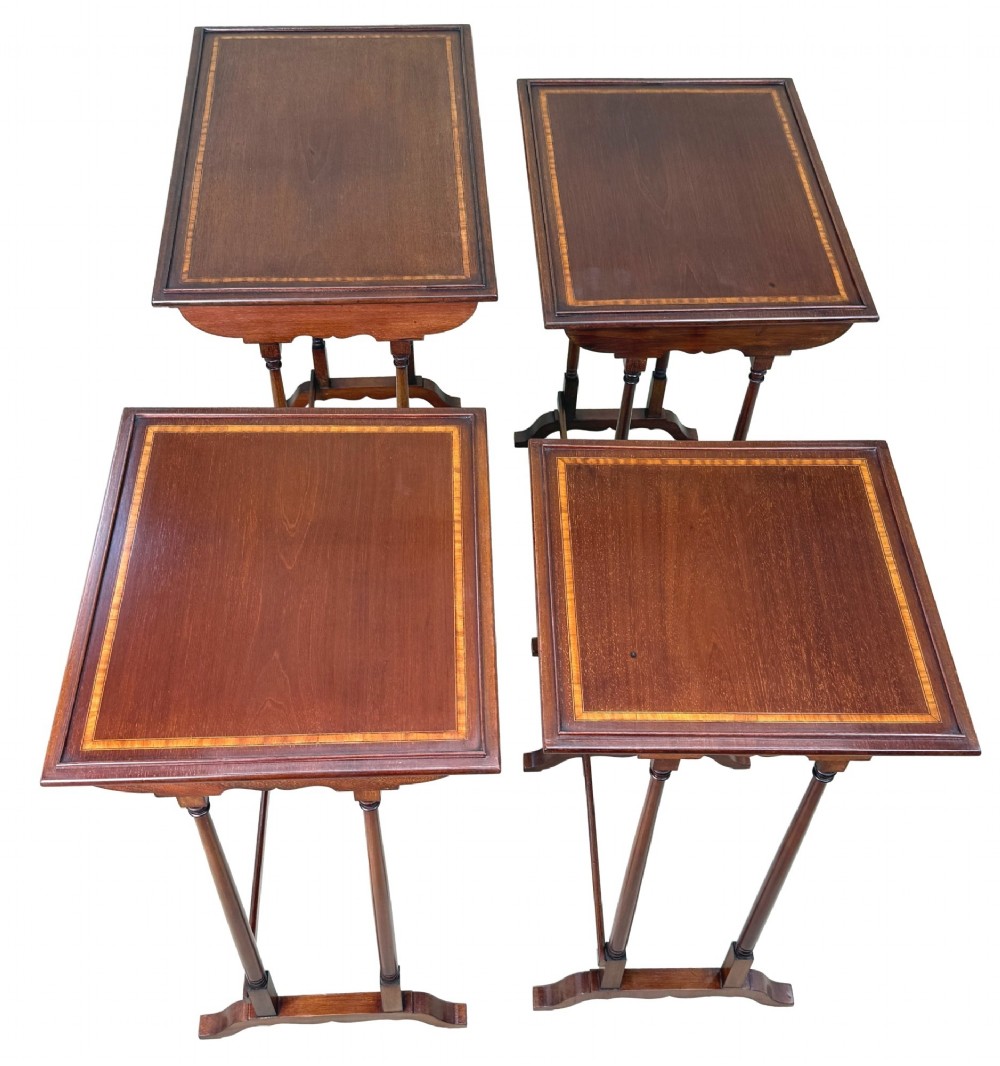A 19th-century set of four graduated mahogany nesting tables featuring slender turned spindle legs and sledge feet. View IX