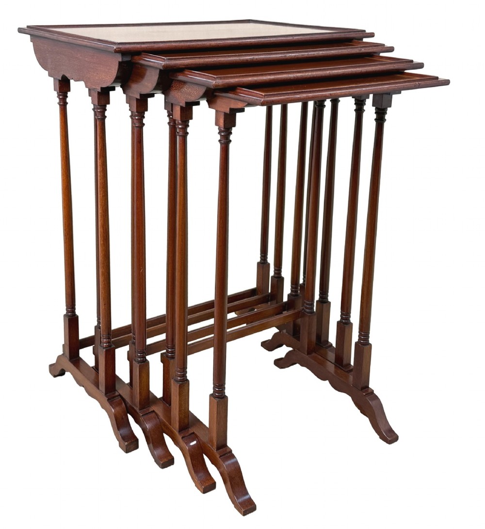 A 19th-century set of four graduated mahogany nesting tables featuring slender turned spindle legs and sledge feet. View X