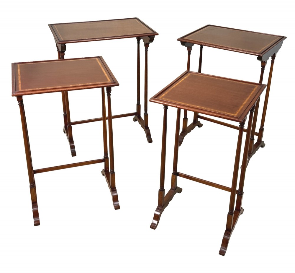 A 19th-century set of four graduated mahogany nesting tables featuring slender turned spindle legs and sledge feet. View XIII