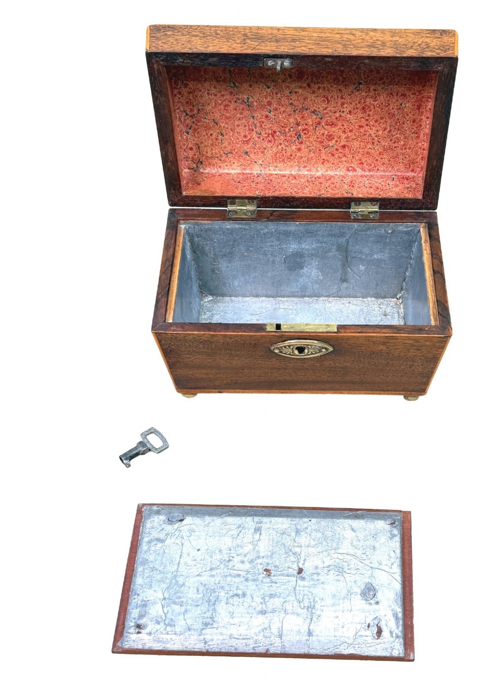 An eighteenth-century Georgian mahogany tea caddy featuring a sarcophagus shape, boxwood edging, an oval brass escutcheon, and brass ball feet. View VI