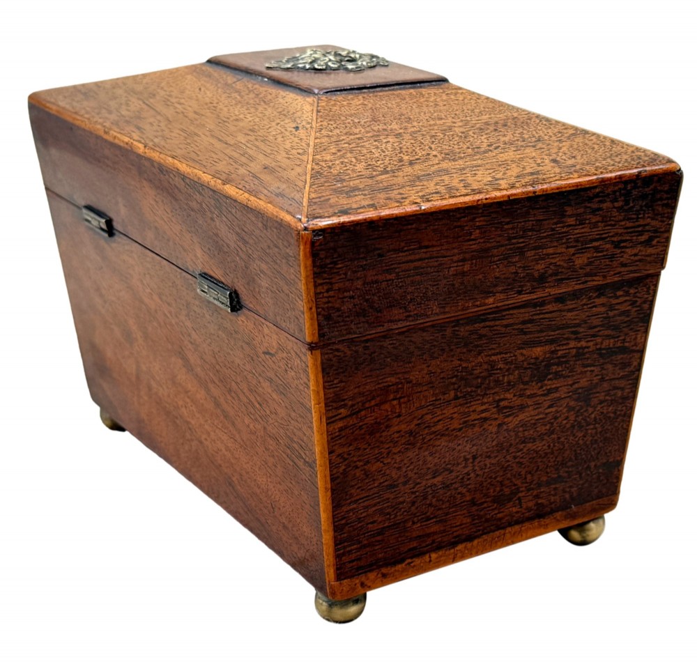 An eighteenth-century Georgian mahogany tea caddy featuring a sarcophagus shape, boxwood edging, an oval brass escutcheon, and brass ball feet. View VII