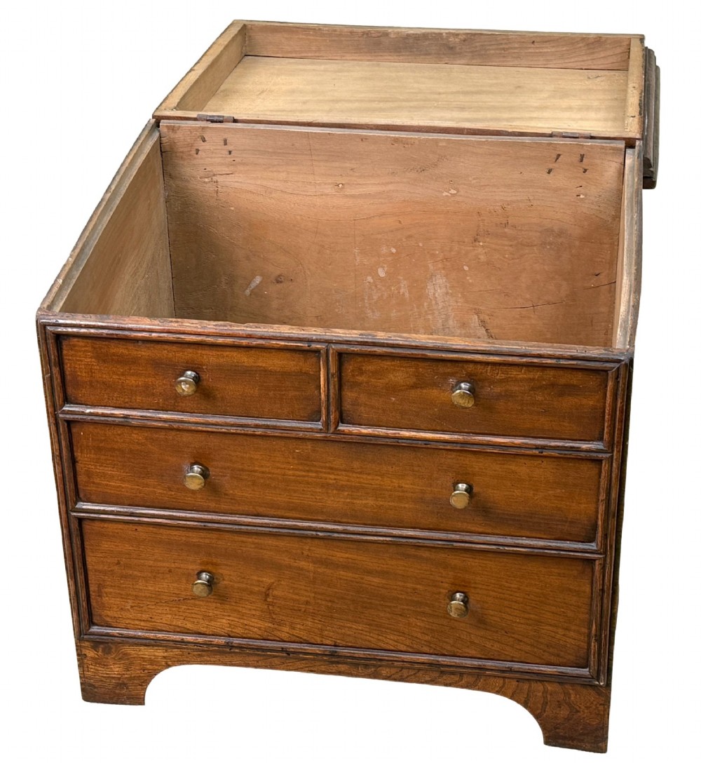 An 18th-century warm brown elm close stool designed as a small Georgian chest of drawers with bracket feet and brass handles. View V