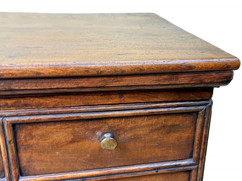 An 18th-century warm brown elm close stool designed as a small Georgian chest of drawers with bracket feet and brass handles. View VI