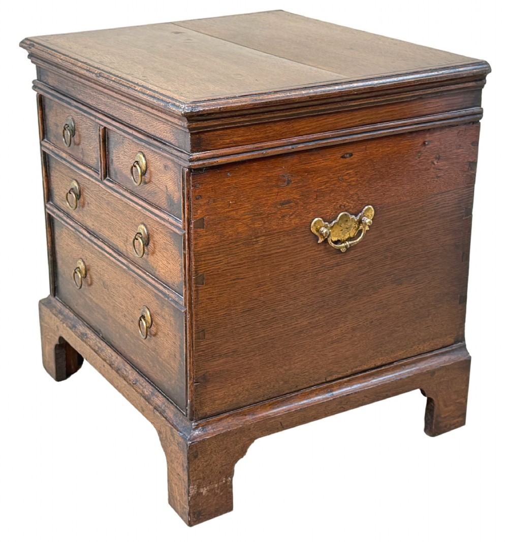 An 18th-century dark oak close stool designed as a small chest with faux drawer fronts, brass ring handles, and bracket feet. View II