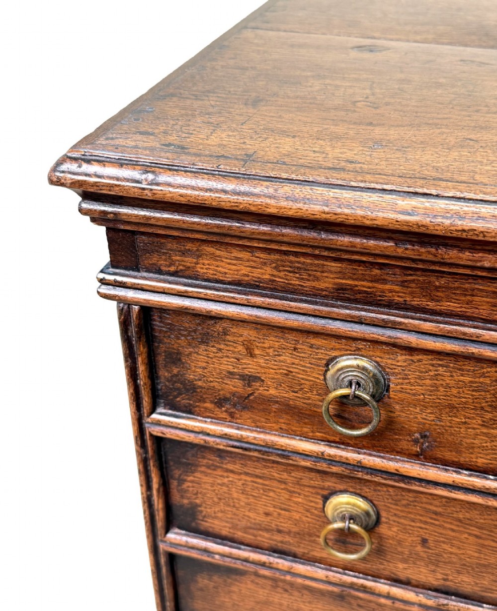 An 18th-century dark oak close stool designed as a small chest with faux drawer fronts, brass ring handles, and bracket feet. View VII