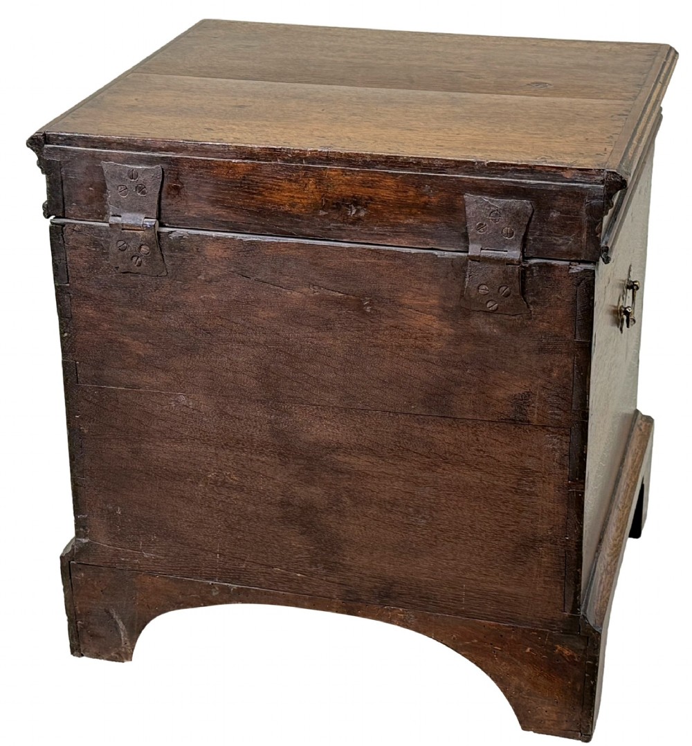An 18th-century dark oak close stool designed as a small chest with faux drawer fronts, brass ring handles, and bracket feet. View IX
