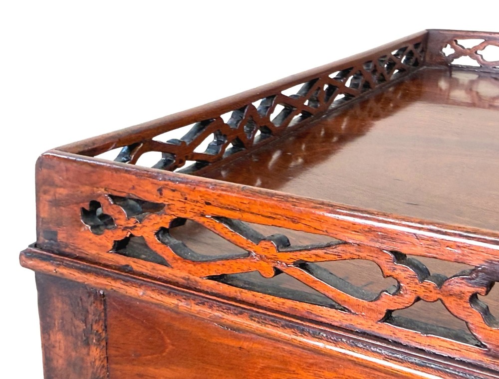 A rectangular dark mahogany silver table featuring a pierced fretwork gallery top, carved corner spandrels, and four straight legs. View II
