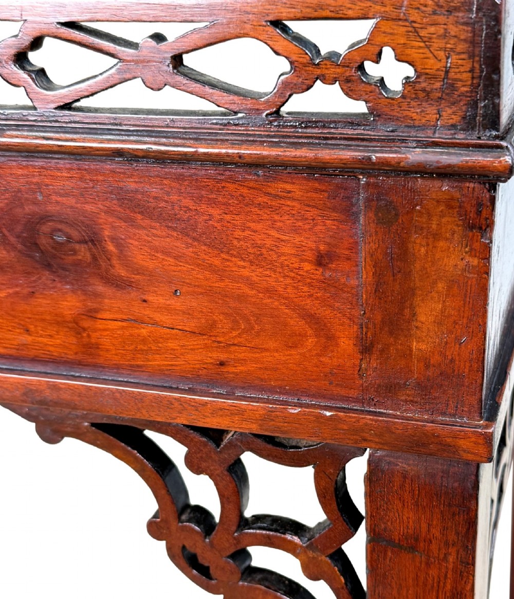 A rectangular dark mahogany silver table featuring a pierced fretwork gallery top, carved corner spandrels, and four straight legs. View IV