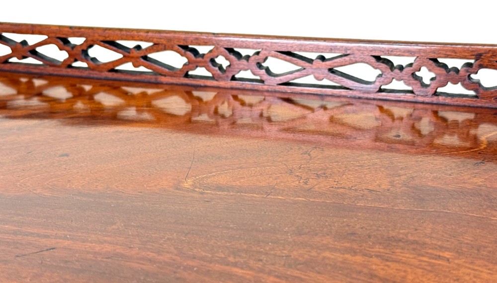 A rectangular dark mahogany silver table featuring a pierced fretwork gallery top, carved corner spandrels, and four straight legs. View X