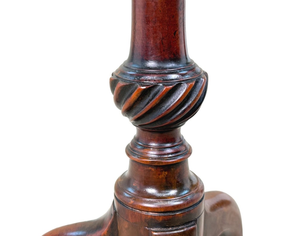An 18th-century mahogany kettle stand with a raised piecrust top on a turned pedestal column and tripod base. View V