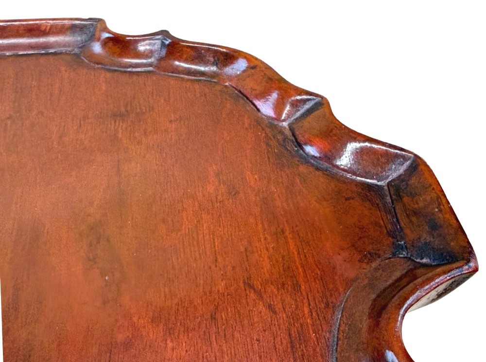 An 18th-century mahogany kettle stand with a raised piecrust top on a turned pedestal column and tripod base. View VII