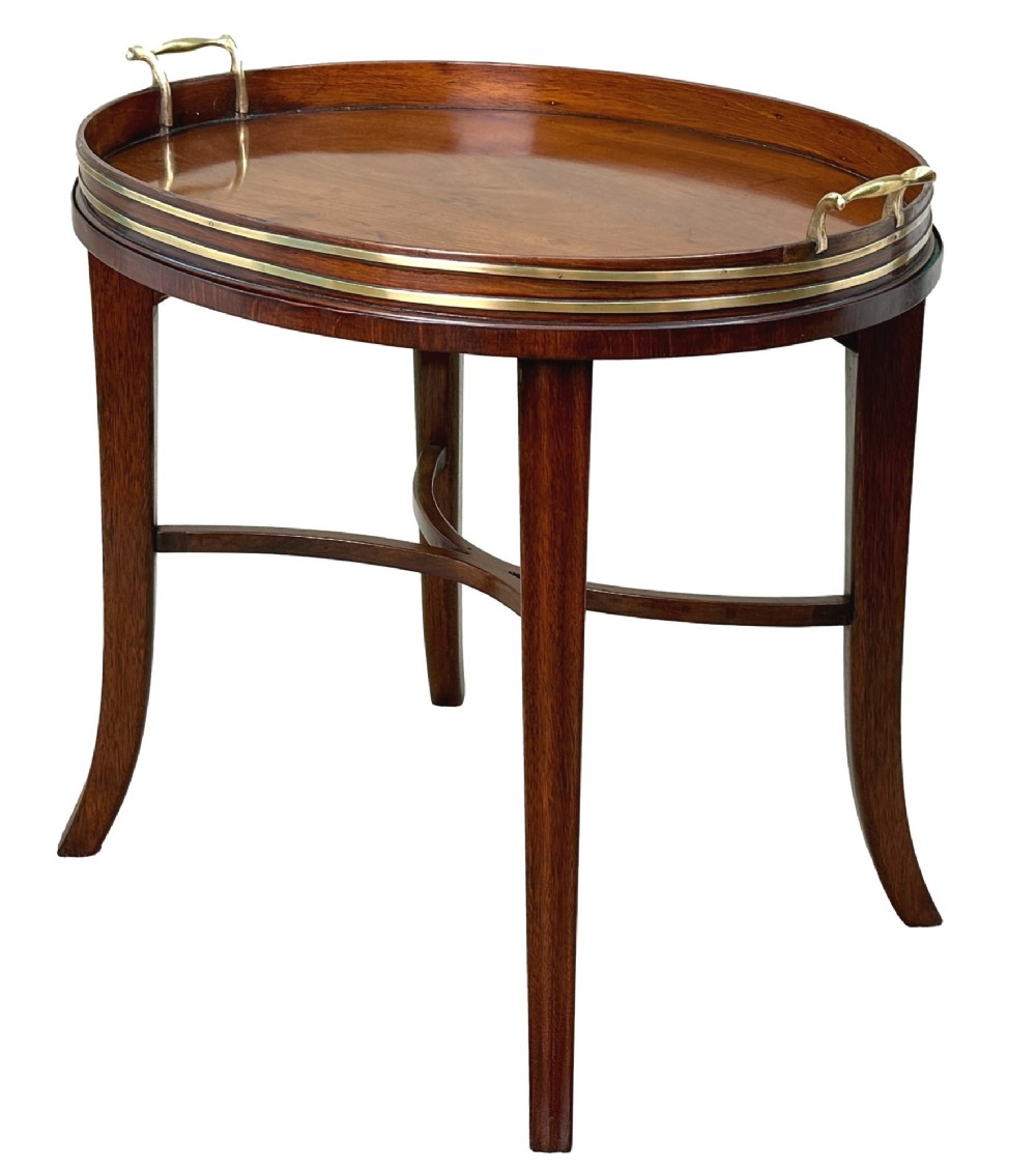 A Georgian mahogany oval tray table featuring a double brass-bound gallery rim, twin side handles, and four splayed legs joined by an X-frame stretcher. View VII