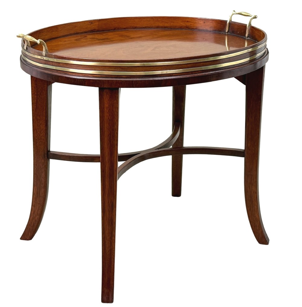 A Georgian mahogany oval tray table featuring a double brass-bound gallery rim, twin side handles, and four splayed legs joined by an X-frame stretcher. View X