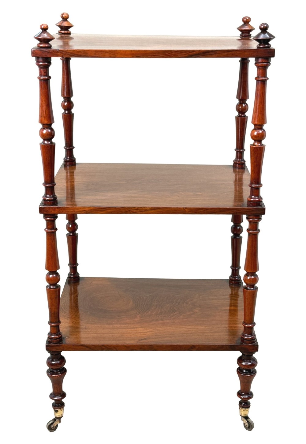 A mid-19th-century rosewood three-tier whatnot with turned spindles, finials, and brass castors. View XIII