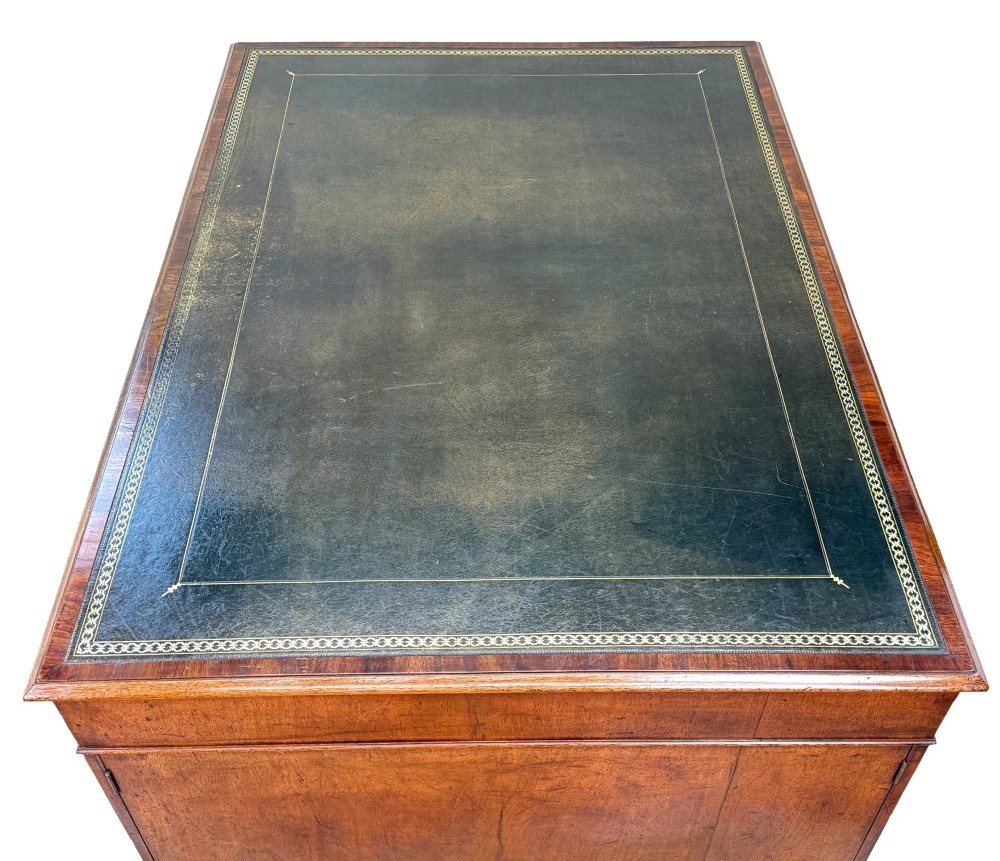 An 18th-century Georgian mahogany partners desk featuring three top frieze drawers and twin pedestal cupboards set on a plinth base. View V
