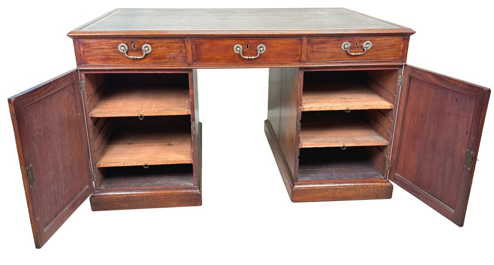 An 18th-century Georgian mahogany partners desk featuring three top frieze drawers and twin pedestal cupboards set on a plinth base. View IX