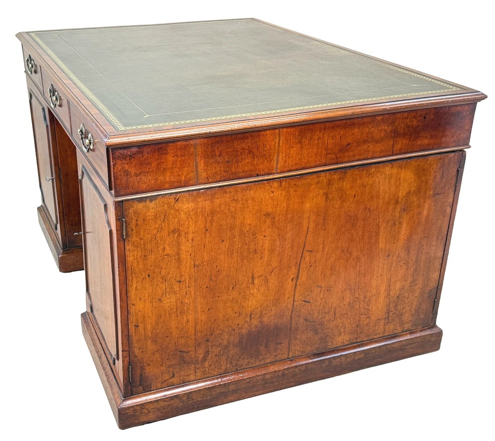 An 18th-century Georgian mahogany partners desk featuring three top frieze drawers and twin pedestal cupboards set on a plinth base. View XI