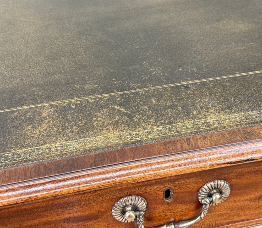 An 18th-century Georgian mahogany partners desk featuring three top frieze drawers and twin pedestal cupboards set on a plinth base. View XII