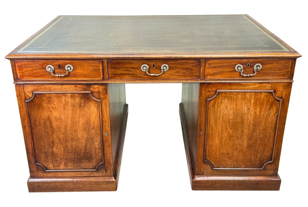 An 18th-century Georgian mahogany partners desk featuring three top frieze drawers and twin pedestal cupboards set on a plinth base. View XIV