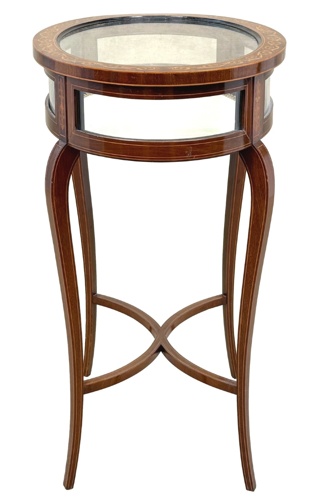 An oval late 19th-century mahogany bijouterie display table featuring glass side panels, inlaid floral marquetry, slender cabriole legs, and a cross stretcher. View IV