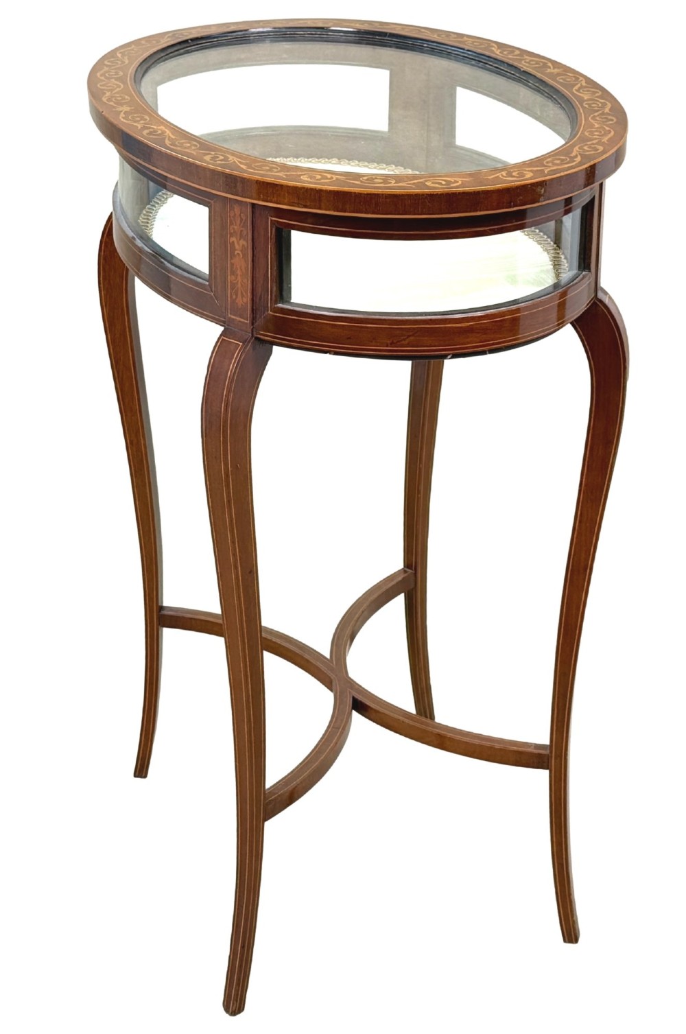 An oval late 19th-century mahogany bijouterie display table featuring glass side panels, inlaid floral marquetry, slender cabriole legs, and a cross stretcher. View X