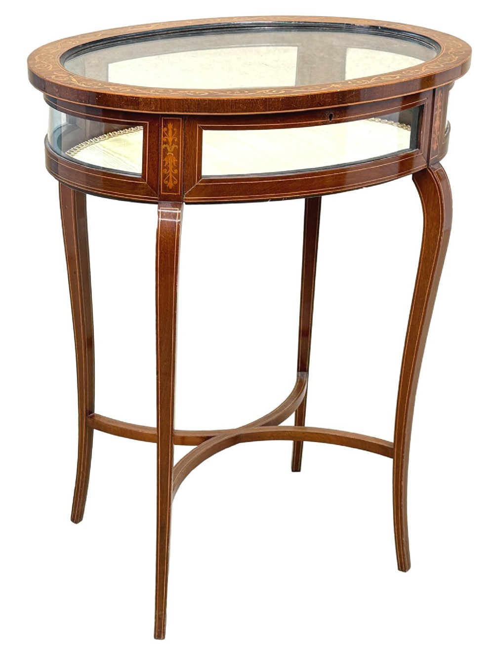 An oval late 19th-century mahogany bijouterie display table featuring glass side panels, inlaid floral marquetry, slender cabriole legs, and a cross stretcher. View XII