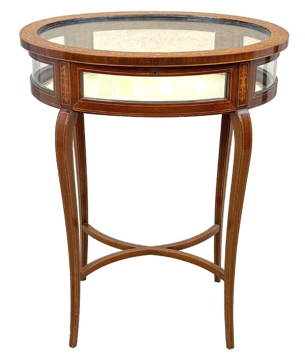 An oval late 19th-century mahogany bijouterie display table featuring glass side panels, inlaid floral marquetry, slender cabriole legs, and a cross stretcher. View XIII