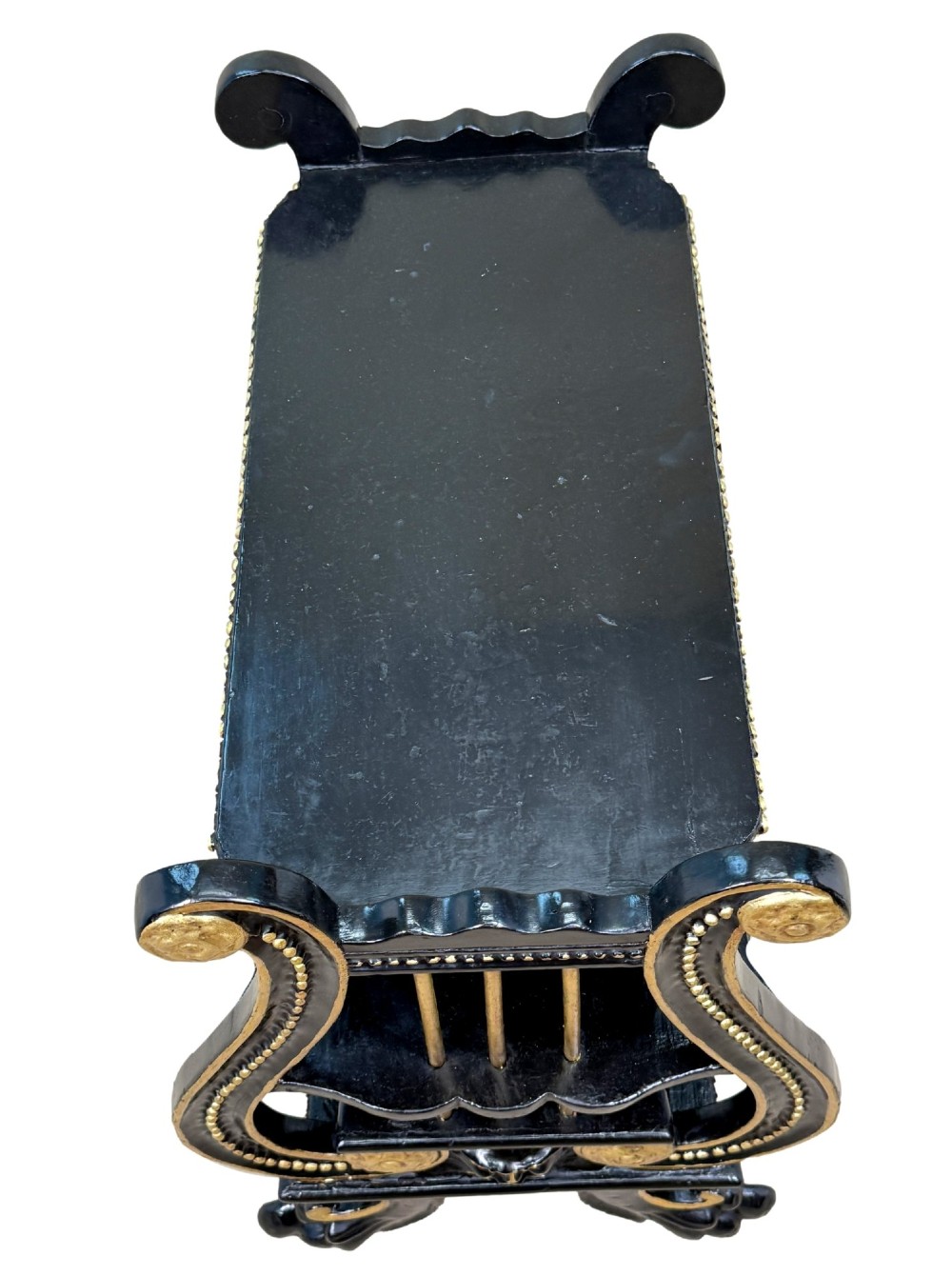 A late nineteenth-century ebonised three-tiered etagere featuring lyre-shaped side supports, gilt bead trim along the shelf edges, and carved scroll feet. View V