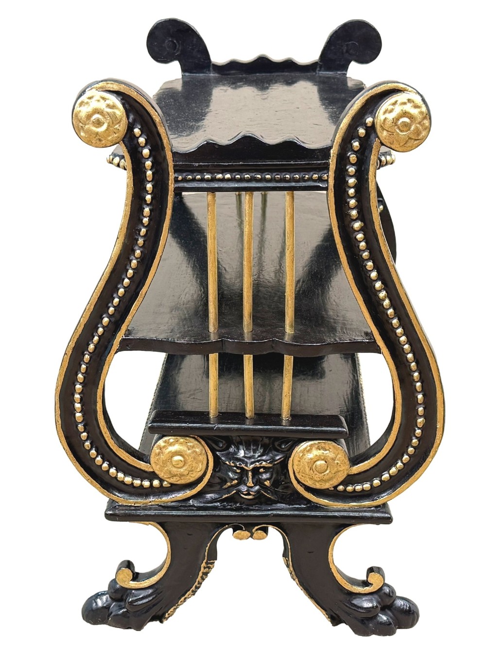 A late nineteenth-century ebonised three-tiered etagere featuring lyre-shaped side supports, gilt bead trim along the shelf edges, and carved scroll feet. View VI
