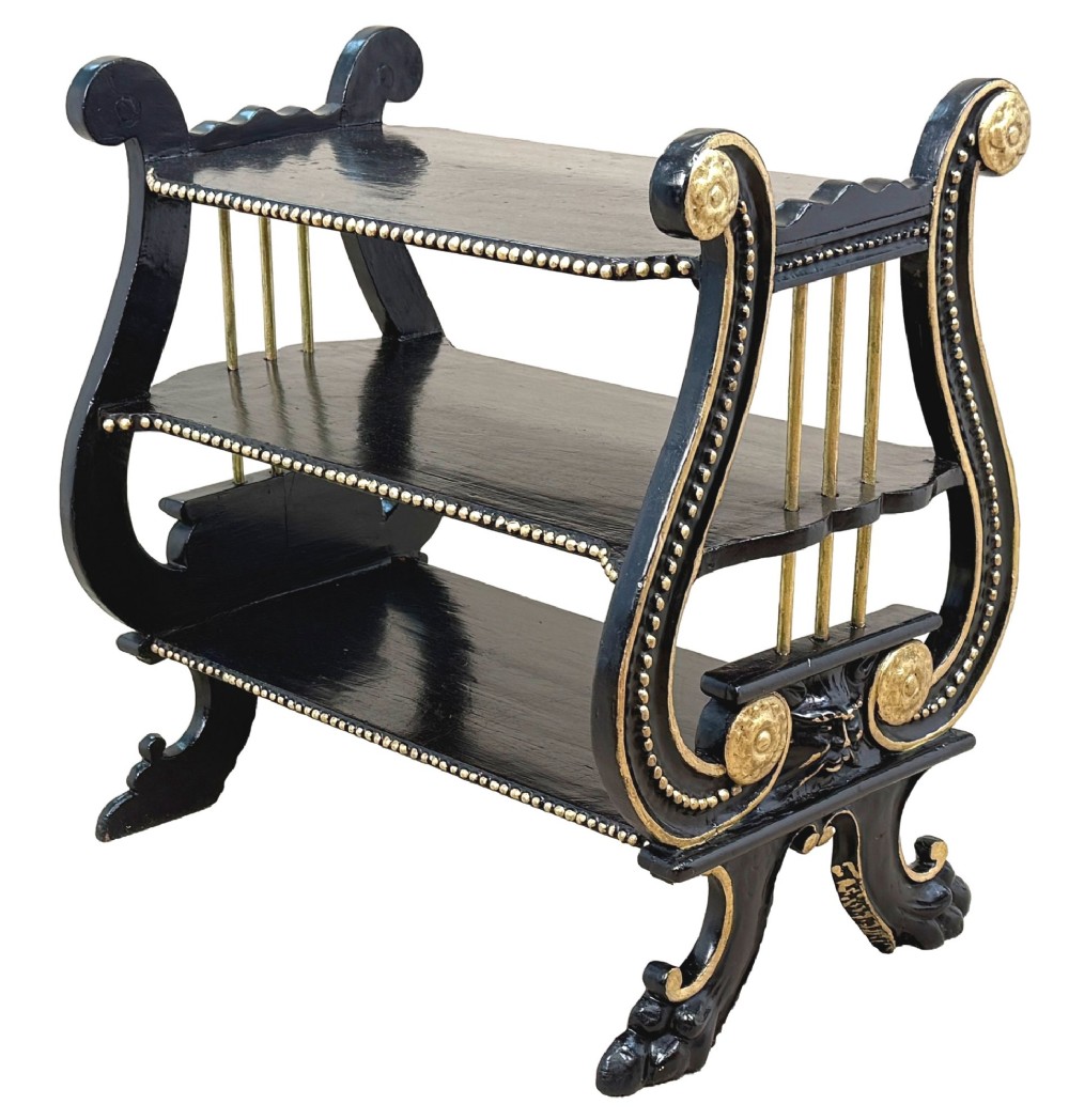 A late nineteenth-century ebonised three-tiered etagere featuring lyre-shaped side supports, gilt bead trim along the shelf edges, and carved scroll feet. View VII