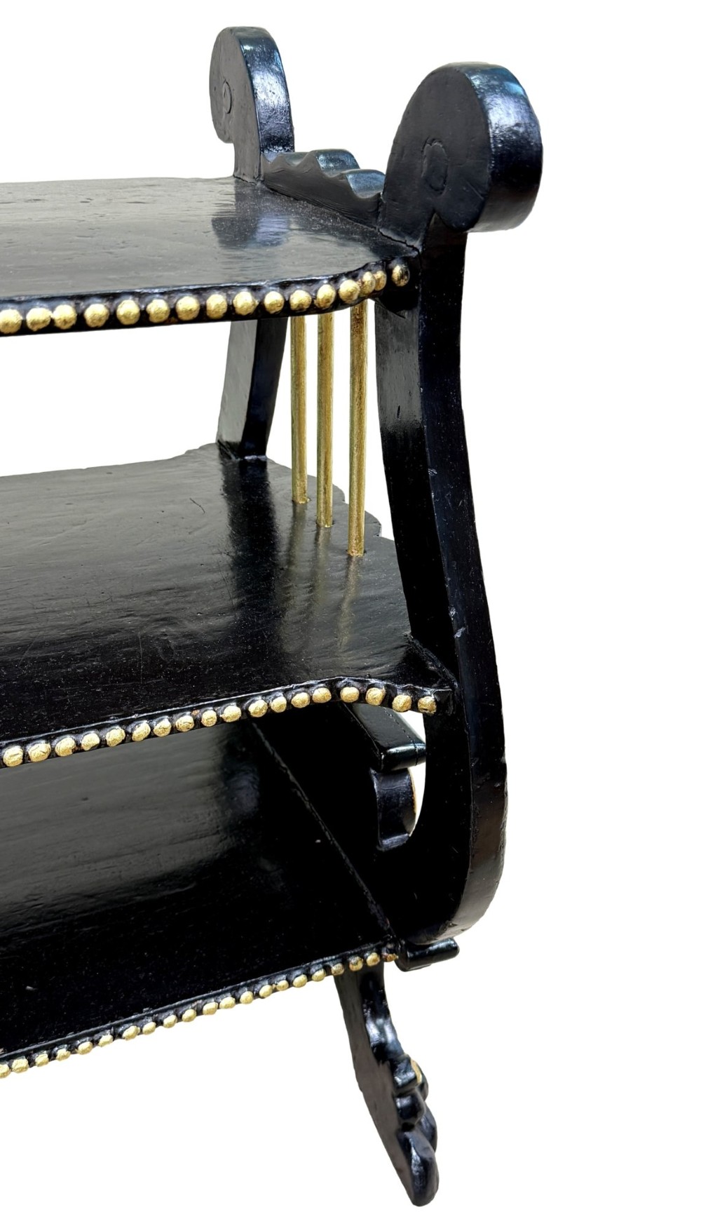 A late nineteenth-century ebonised three-tiered etagere featuring lyre-shaped side supports, gilt bead trim along the shelf edges, and carved scroll feet. View IX