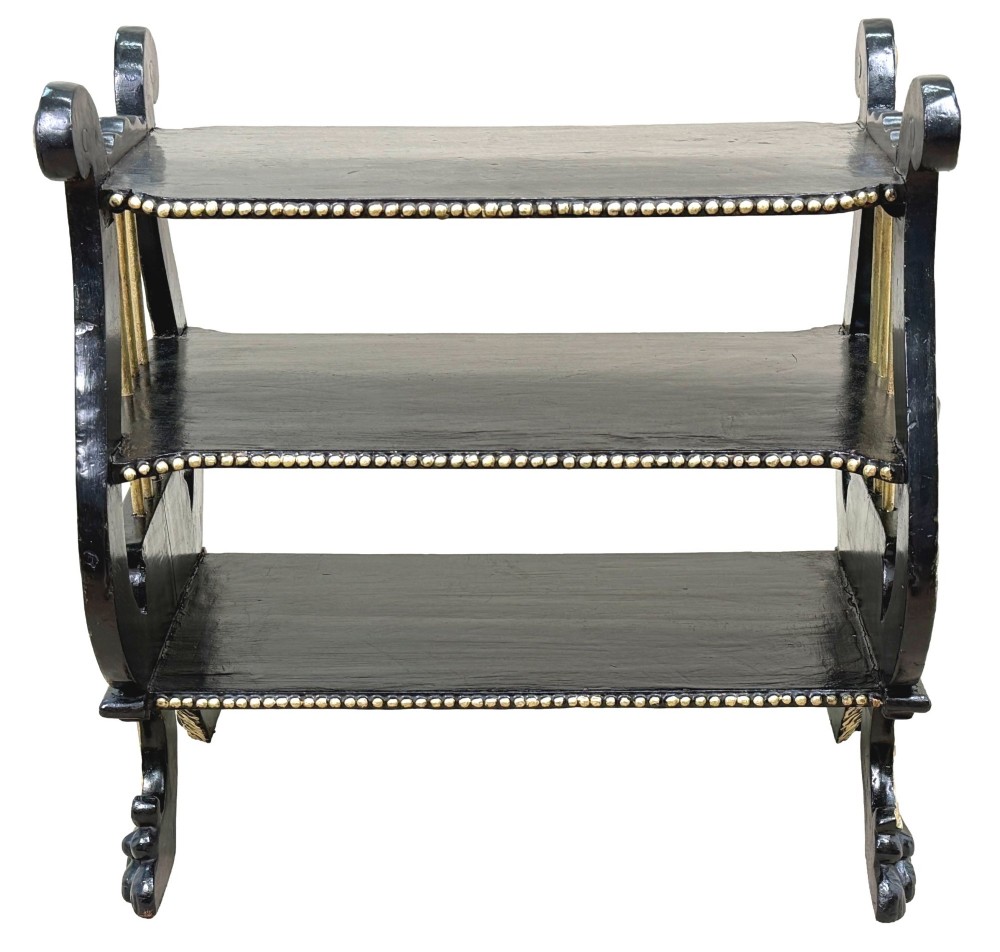 A late nineteenth-century ebonised three-tiered etagere featuring lyre-shaped side supports, gilt bead trim along the shelf edges, and carved scroll feet. View XI