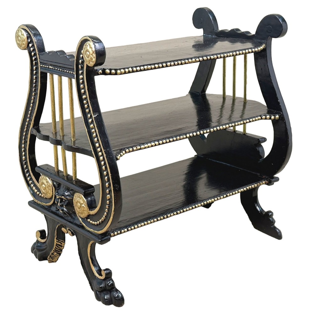 A late nineteenth-century ebonised three-tiered etagere featuring lyre-shaped side supports, gilt bead trim along the shelf edges, and carved scroll feet. View XII