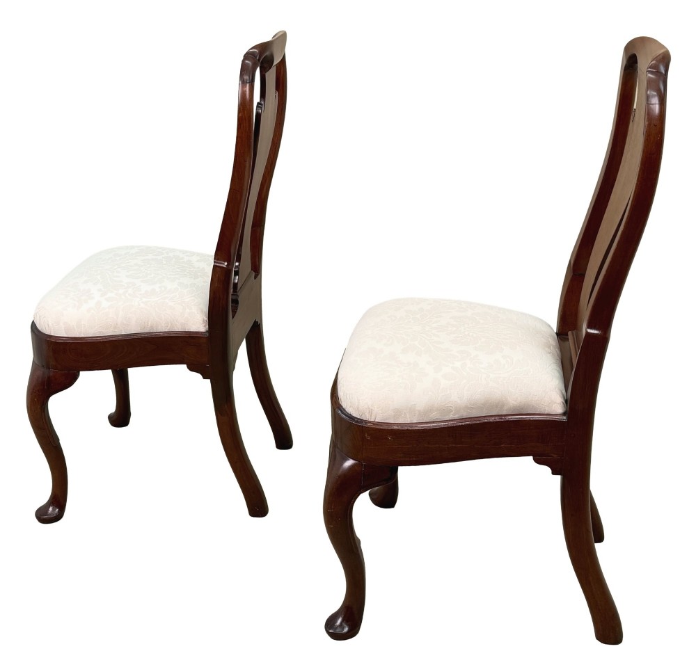 A pair of early 18th-century Queen Anne walnut side chairs featuring vase-shaped back splats, curved cabriole front legs, and cream upholstered drop-in seats. View IV
