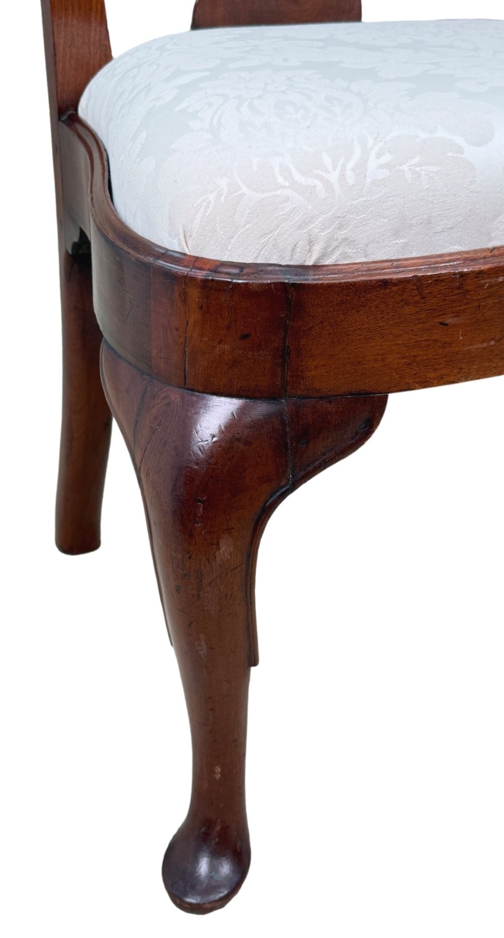 A pair of early 18th-century Queen Anne walnut side chairs featuring vase-shaped back splats, curved cabriole front legs, and cream upholstered drop-in seats. View V
