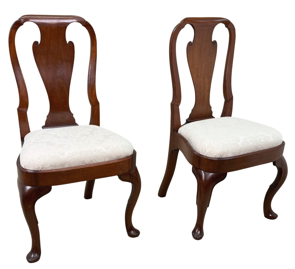 A pair of early 18th-century Queen Anne walnut side chairs featuring vase-shaped back splats, curved cabriole front legs, and cream upholstered drop-in seats. View VII