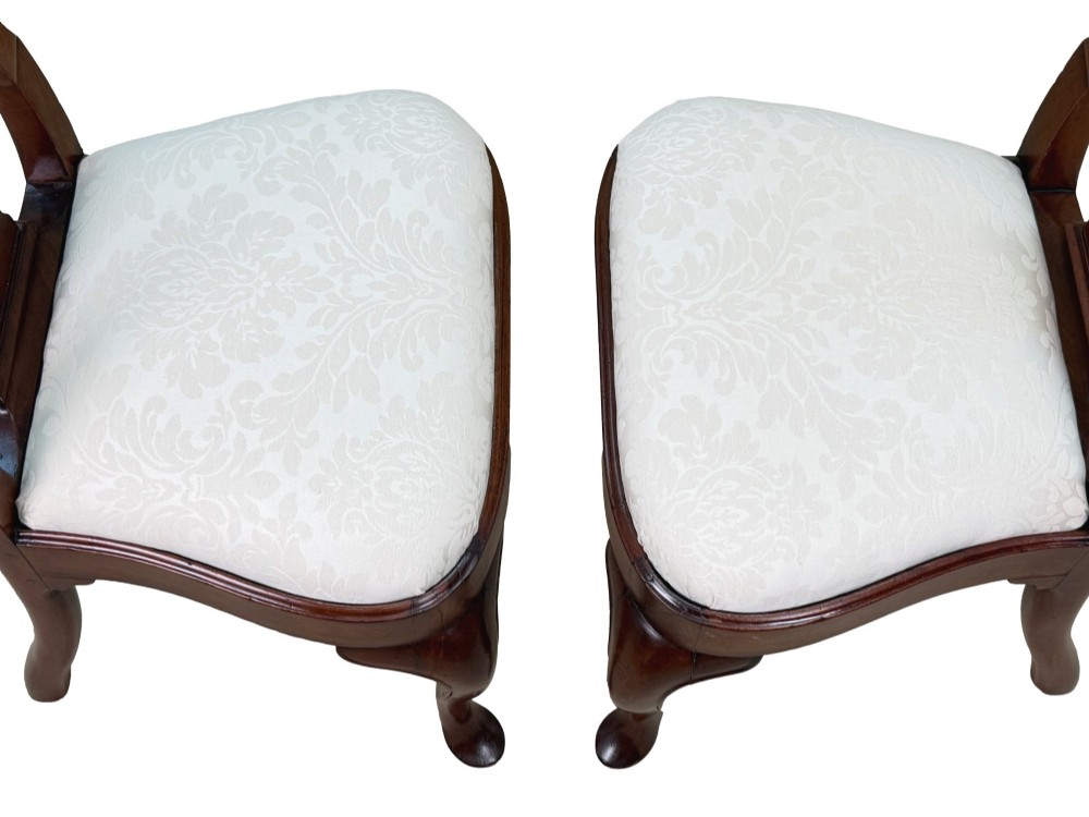 A pair of early 18th-century Queen Anne walnut side chairs featuring vase-shaped back splats, curved cabriole front legs, and cream upholstered drop-in seats. View VIII
