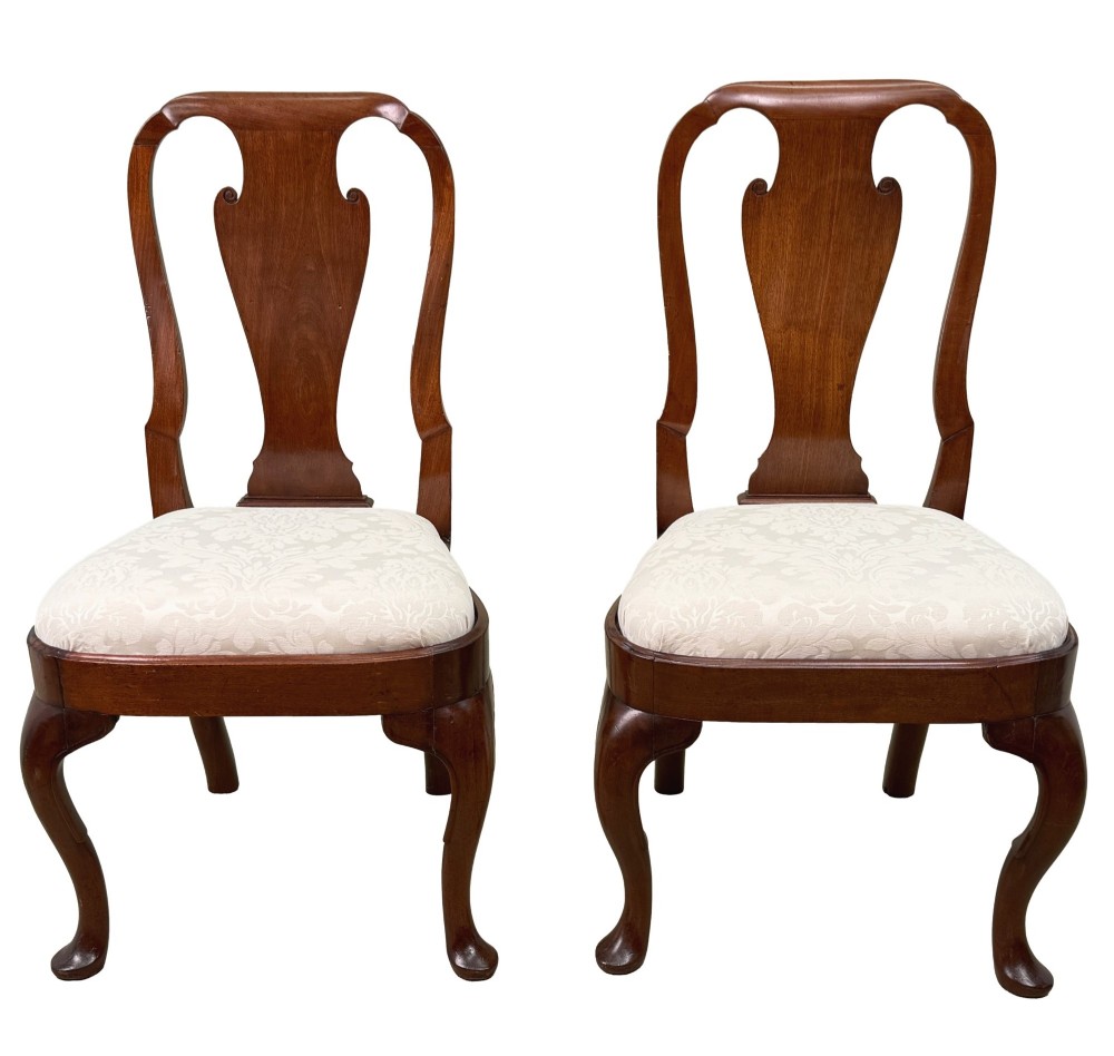 A pair of early 18th-century Queen Anne walnut side chairs featuring vase-shaped back splats, curved cabriole front legs, and cream upholstered drop-in seats. View XII