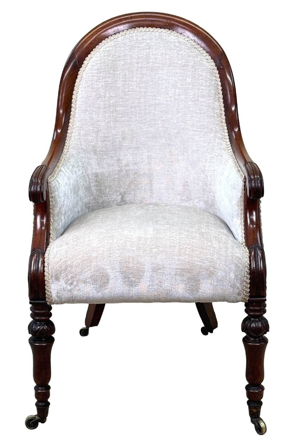 A 19th-century English Regency mahogany tub armchair with cream upholstery, scrolled armrests, turned legs, and brass castors. View X