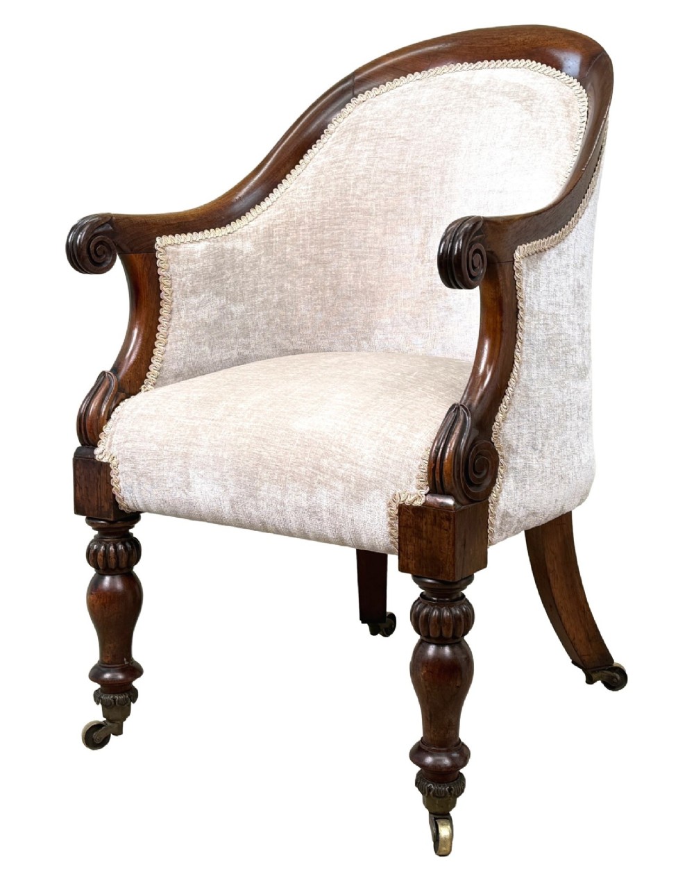 A 19th-century Regency period rosewood tub library armchair upholstered in cream fabric with turned legs and brass castors.