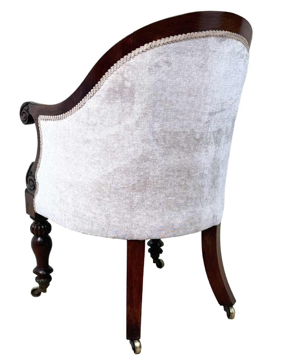 A 19th-century Regency period rosewood tub library armchair upholstered in cream fabric with turned legs and brass castors. View V