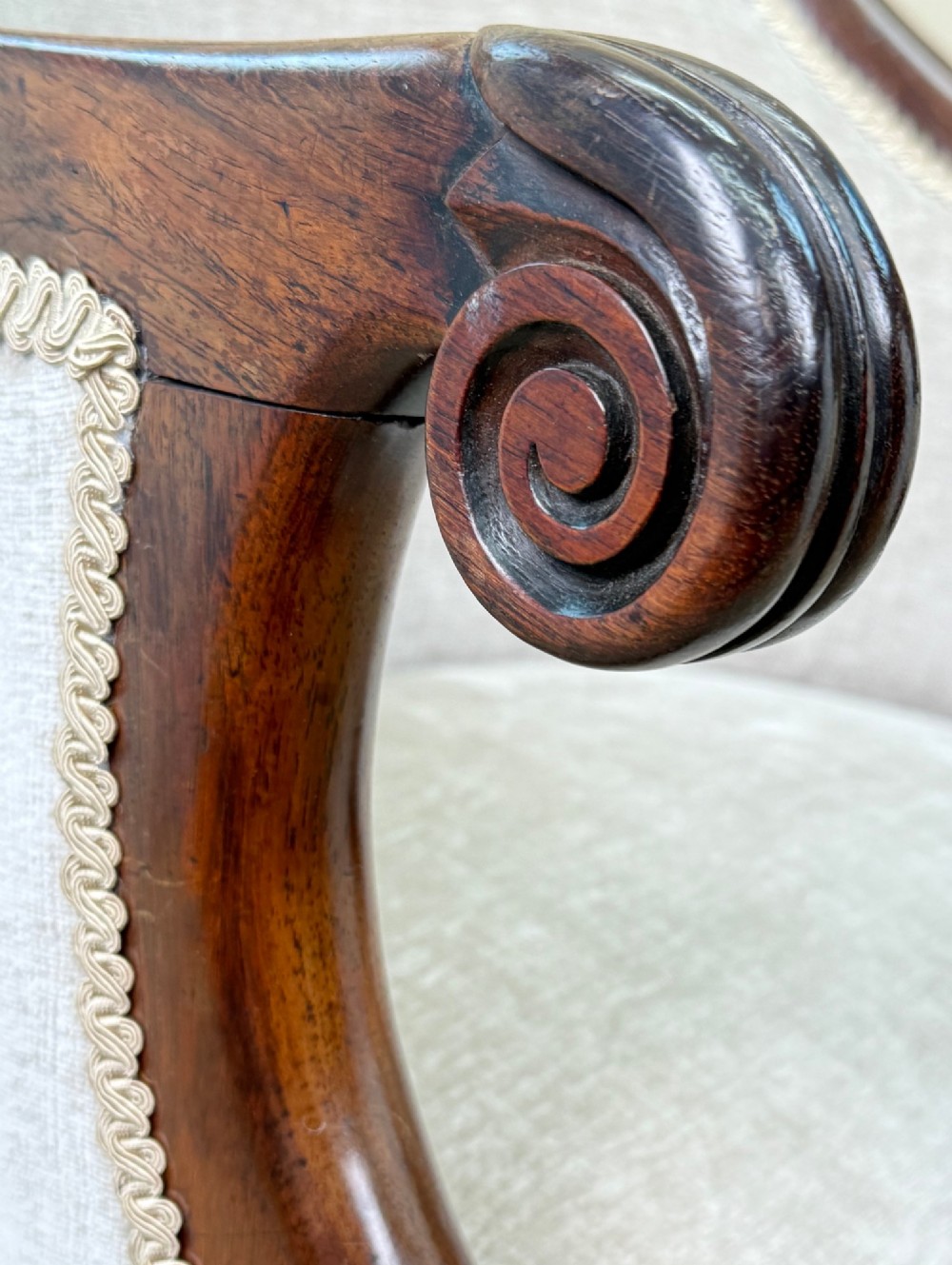 A 19th-century Regency period rosewood tub library armchair upholstered in cream fabric with turned legs and brass castors. View VI
